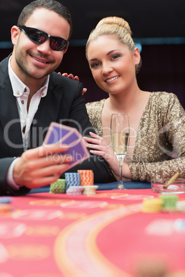 Couple sitting at the poker table smiling