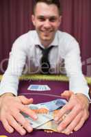 Man grabbing money at poker table