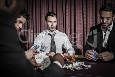 Serious man looking up from high stakes poker game