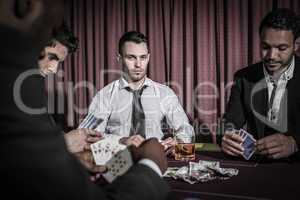 Serious man looking up from high stakes poker game