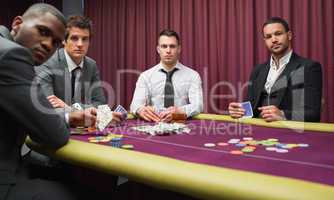 Men looking up from high stakes poker game