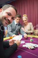 Man smiling while sitting at poker table