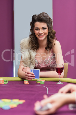 Woman sitting at the table smiling holding cards