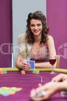 Woman sitting at the table smiling holding cards