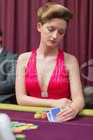 Woman sitting at table holding cards