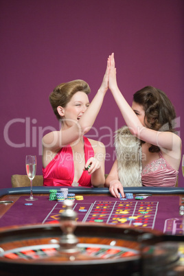 Women high fiving at roulette table