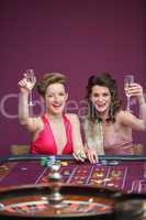 Women raising champagne glasses at roulette table