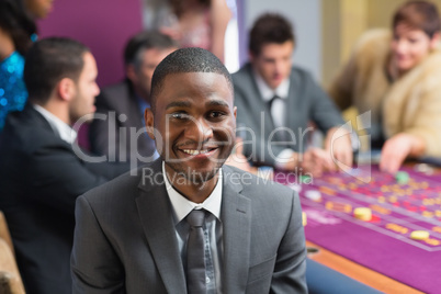 Smiling man sitting at roulette table