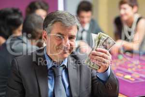 Man holding up money at roulette table