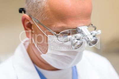 Mature dentist surgeon at office special glasses