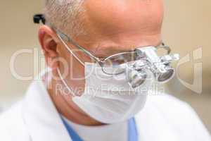 Mature dentist surgeon at office special glasses