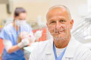 Mature dentist surgeon at office portrait