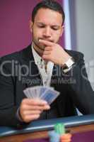 Man looking at his cards thinking