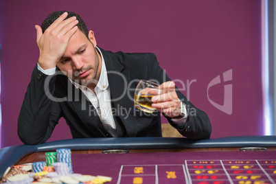 Man looking at whiskey glass