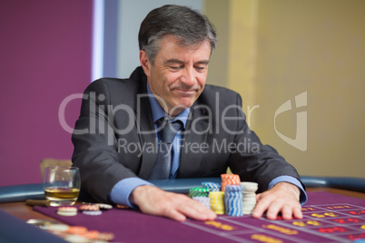 Man sitting at table looking at chips Man sitting at table looking at chips