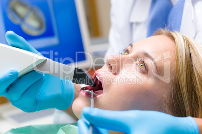 Woman with open mouth and dental tools