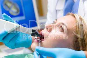 Woman with open mouth and dental tools