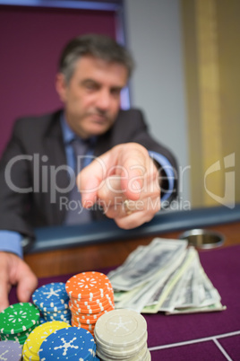 Man with chips and cash pointing