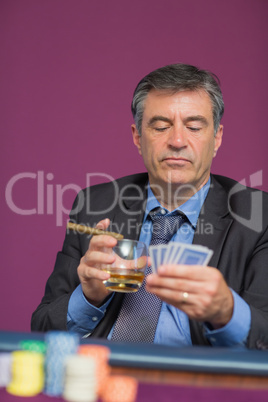 Man sitting looking at his cards