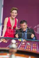 Man and woman cheering at roulette table