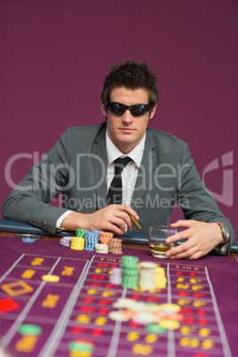 Man wearing sun glasses at roulette table