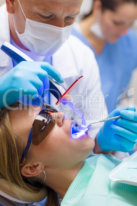 Dentist use UV lamp female patient