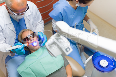 Dentist use UV lamp female patient