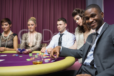 Man looking up from poker game and smiling