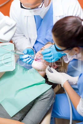 Dentist with nurse doing procedure on patient