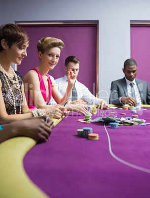 Woman smiling and looking up from poker game