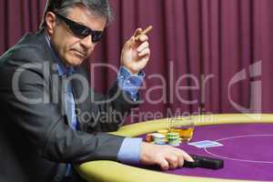 Man with gun at poker table