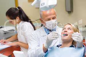 Dentist doing procedure on young patient woman