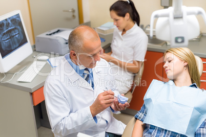 Dentist show patient woman model of teeth