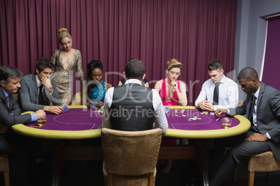 People sitting at the poker table playing