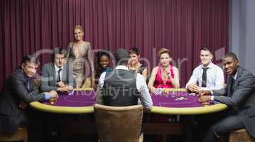 Smiling group sitting around poker table