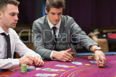 Men placing bets at poker game