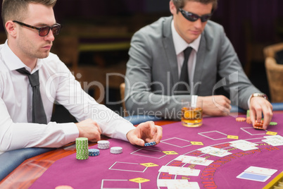 Men sitting at the table wearing sun glasses