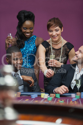 Women with champagne standing at roulette table