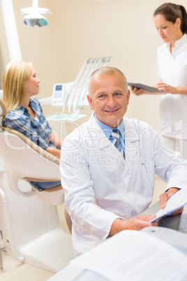 Mature dentist surgeon at office with patient