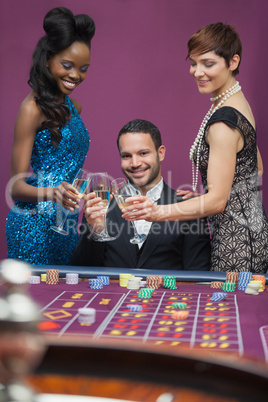 Man and women clinking glasses