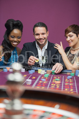 Man playing roulette with two women