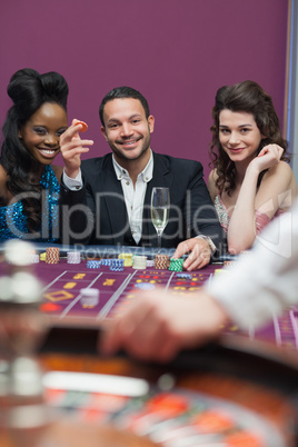 Man and women sitting at roulette table smiling