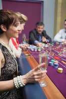 Woman holding glass of champagne at roulette