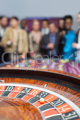 People standing looking at the roulette wheel