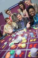 Man surrounded by women at roulette table