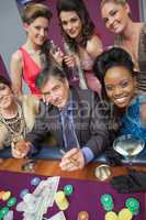 Man surrounded by beautiful women at roulette table