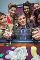 Women surrounding man at roulette table