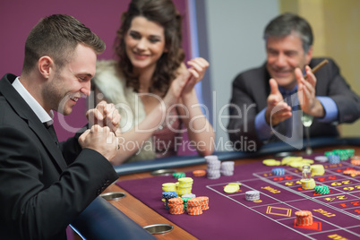 People cheering man at craps game