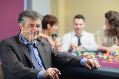 Man with cigar taking break from roulette table