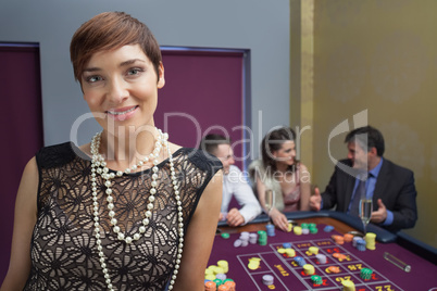 Woman smiling and standing at roulette table